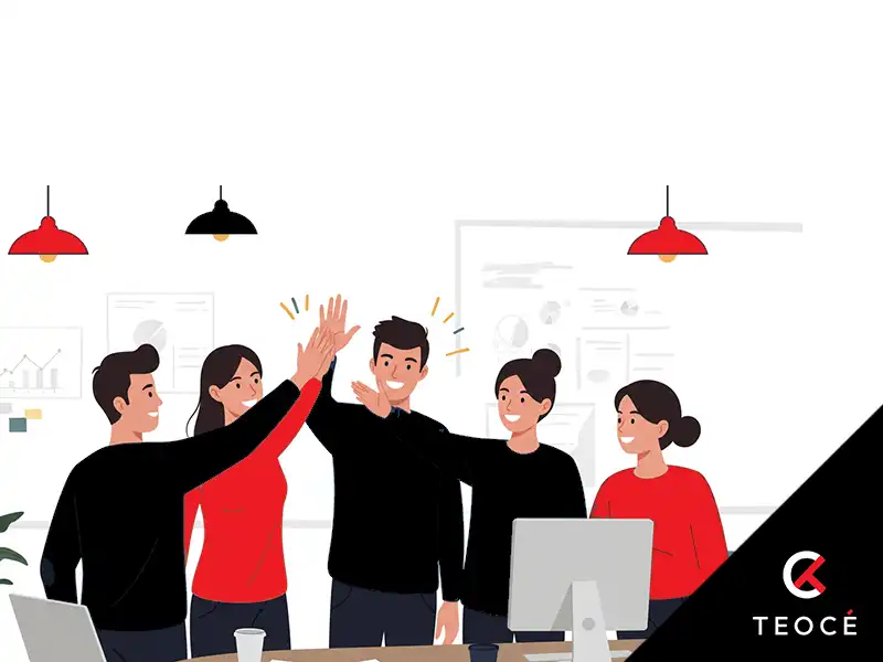 Equipo de trabajo celebrando con un 'high five' frente al ordenador, simbolizando la motivación y los resultados positivos tras implementar una gestión de proyectos eficaz. Imagen de Teocé.